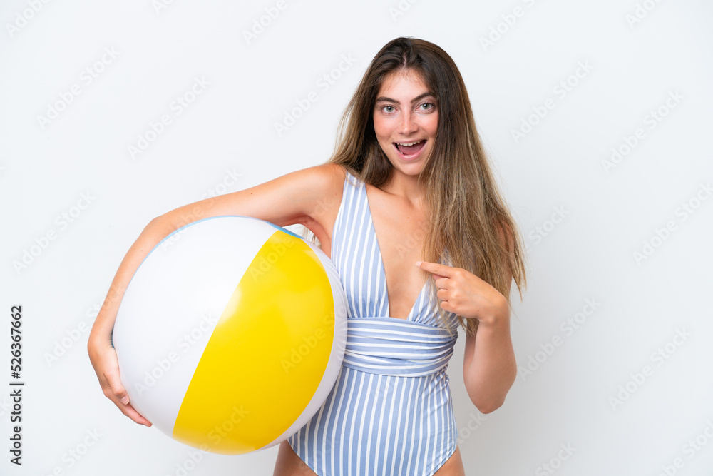 Young woman in swimsuit holding beach ball isolated on white background with surprise facial expression Young woman in swimsuit holding beach ball isolated on white background with surprise facial expression