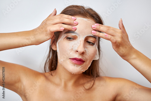 A girl uses a mask for facial care. Beauty concept, skin care cosmetics, facelift. Beauty salon. Removal of wrinkles.