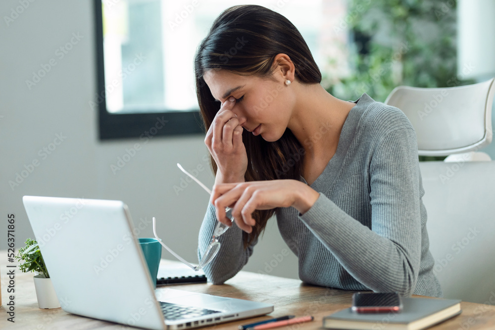 Stressed business woman working from home on laptop looking worried, tired and overwhelmed. Stressed business woman working from home on laptop looking worried, tired and overwhelmed.