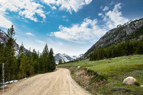 Fotografie Twisted and curvy unpaved dirt country road leading into the hazy mountains lead