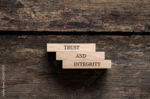 Trust and integrity sign written on three stacked wooden pegs