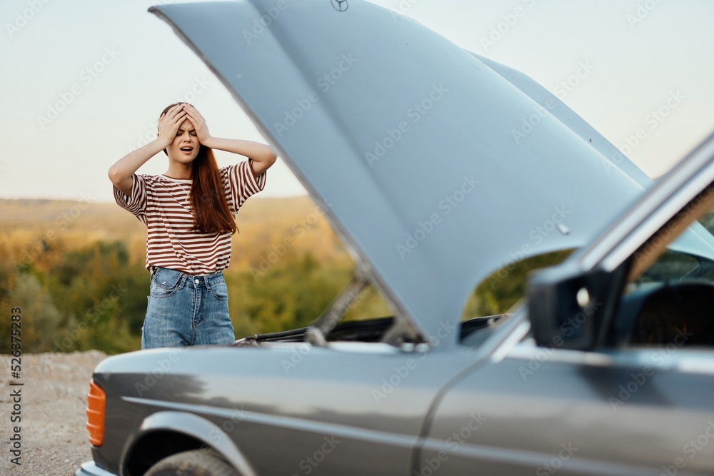 Woman is sad and angry about car breakdown on road trip alone and crying