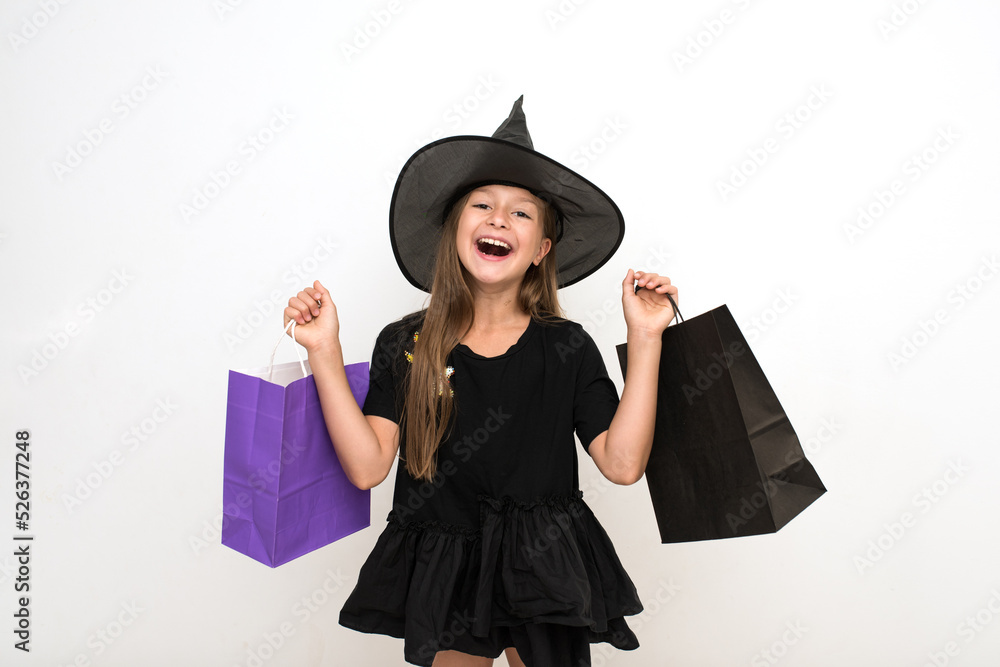Discounts, sales, seasonal sales. Fashion. a girl with long dark hair in a witch hat and bags in her hands. A Halloween party. October 31st. Happy Halloween. Discounts, sales, seasonal sales. Fashion. a girl with long dark hair in a witch hat and bags in her hands. A Halloween party. October 31st. Happy Halloween.