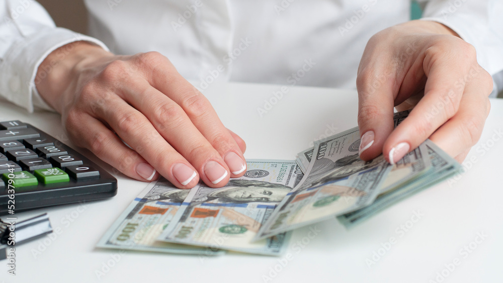savings, finances, economy and home concept - close up of woman with calculator counting money and making notes at home. savings, finances, economy and home concept - close up of woman with calculator counting money and making notes at home.