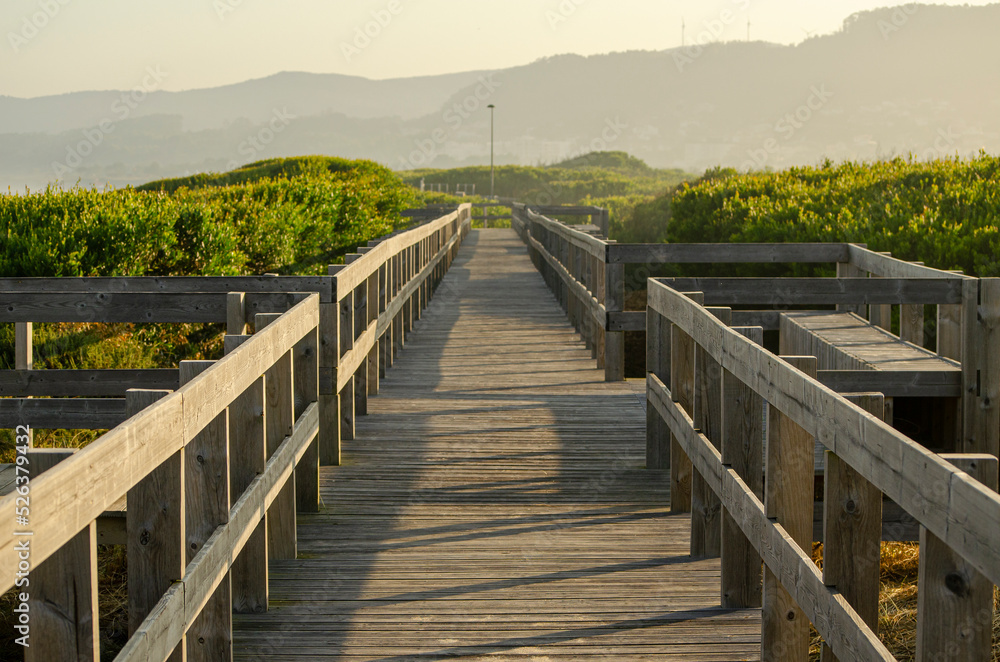 Wooden walkway on a beach at sunrise