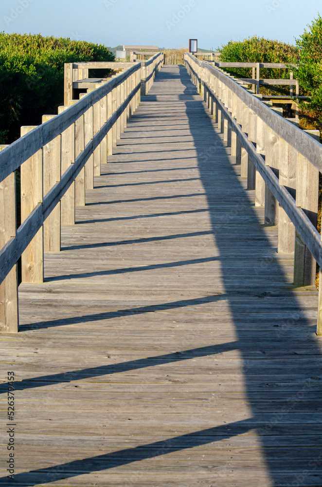 Wooden boardwalk on a beach at sunrise