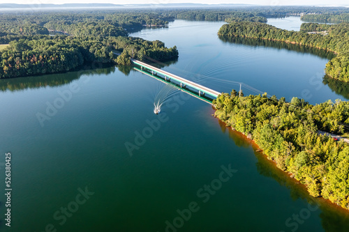 A lake photo taken from a drone. A boat coming under a bridge on Tims Ford in Tennessee