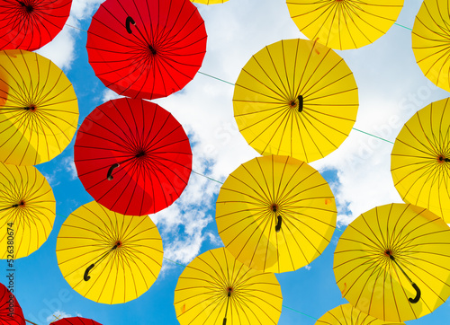 Bright color umbrellas hanging bottom-up sky background
