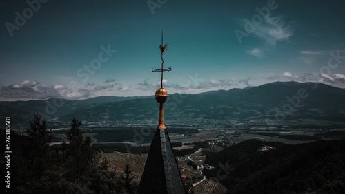 Foto Bell tower of a church with a cross and a rooster on its roof overlooking a gorg
