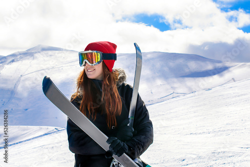 Women, girl in winter overalls,ski mask,glasses with skis,on snow hill looking at high Carpathian mountains at winter alpine ski resort holiday, outdoor nature landscape, Ukraine, Europe.aerial view