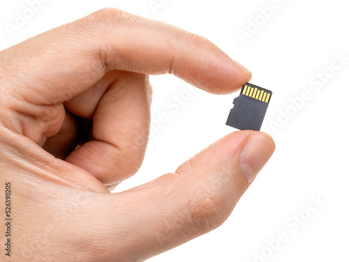 A man's hand holds a micro sd card with two fingers. Isolated on white background