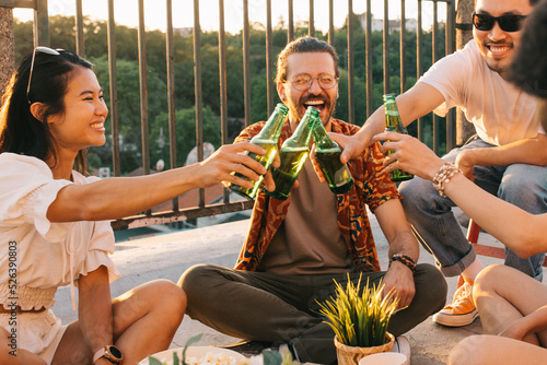 A group of friends toast with beer at the roof party.