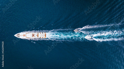 An aerial view of the yacht on the blue sea. Transparent clear water in the sea. Summer vacations and travels on a yacht. Summer relaxation.