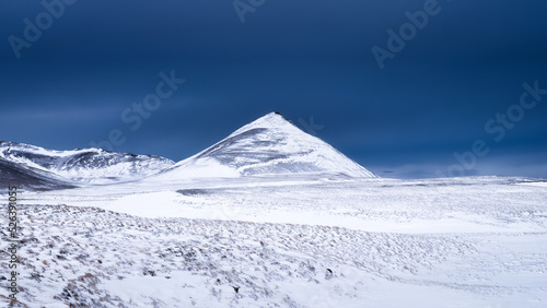 A panoramic view of the plain and mountains in Iceland. Wild landscape and dark skies before the storm. A view of Iceland's nature in winter time.