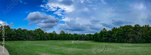 Panorama of a lawn in a park with several goals spread in different parts of the grass space used for playing recreational lacrosse and other ball games.