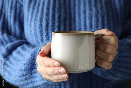 Woman holding cup of hot winter drink, closeup