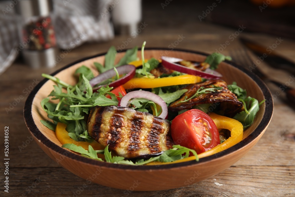 Delicious salad with roasted eggplant and arugula served on wooden table Delicious salad with roasted eggplant and arugula served on wooden table