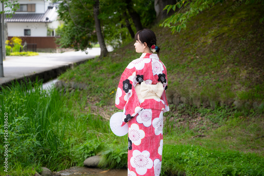 浴衣を着て神社をお参りする若い女性