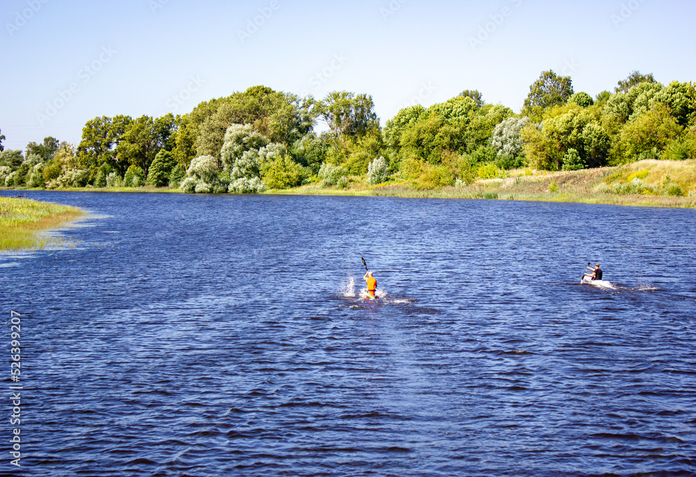 Athletes in kayaks, kayaks, canoes. Sports rowing on the river.