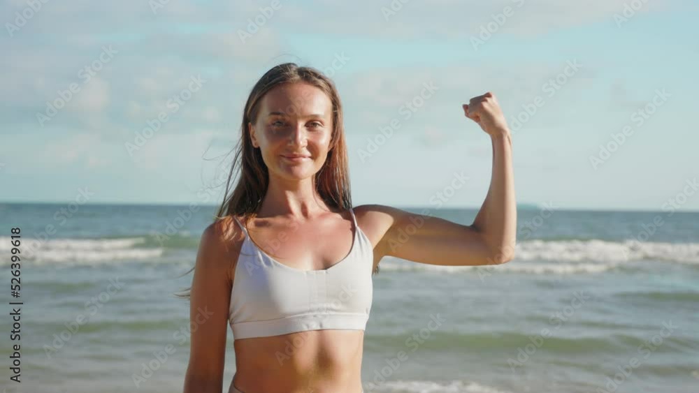 portrait woman after workout looks at camera demonstrate biceps arm. portrait woman after workout looks at camera demonstrate biceps arm.