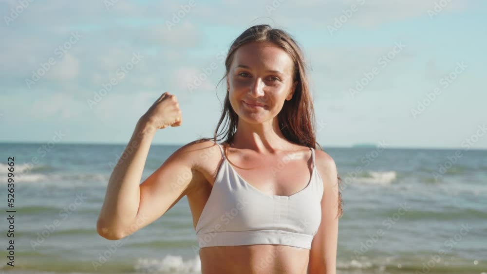 portrait woman after workout looks at camera demonstrate biceps arm. portrait woman after workout looks at camera demonstrate biceps arm.