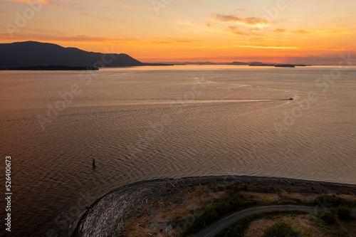 Aerial View of a Pleasure Boat Cruising the San Juan Islands at Sunset. During a glorious sunset a runabout runs through Rosario strait seen from the coast of Lummi island.  photo