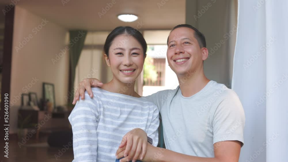 Cheerful young Asian family couple smiling bonding looking at the camera. husband and wife happy faces at home. close up portrait Cheerful young Asian family couple smiling bonding looking at the camera. husband and wife happy faces at home. close up portrait