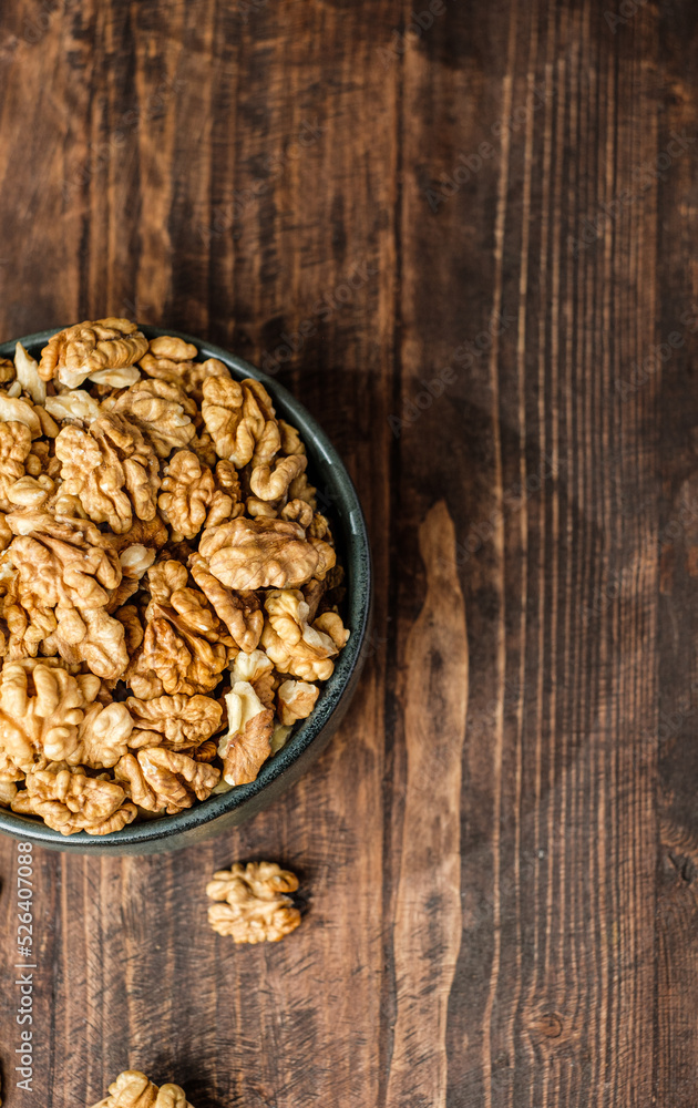 top view walnut in ceramic bowl on kitchen wooden table top view walnut in ceramic bowl on kitchen wooden table