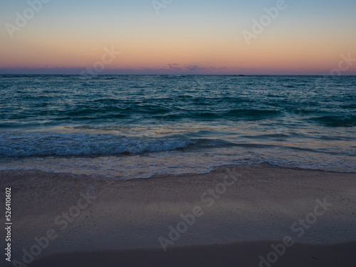 Fototapeta Naklejka Na Ścianę i Meble -  Sunset on the ocean. A beautiful beach with white sand, a turquoise wave runs onto the shore. Relaxing landscape without people