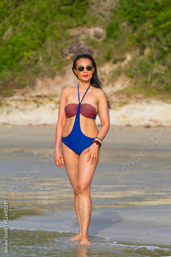 Woman with swimsuit stand relax in morning at beach