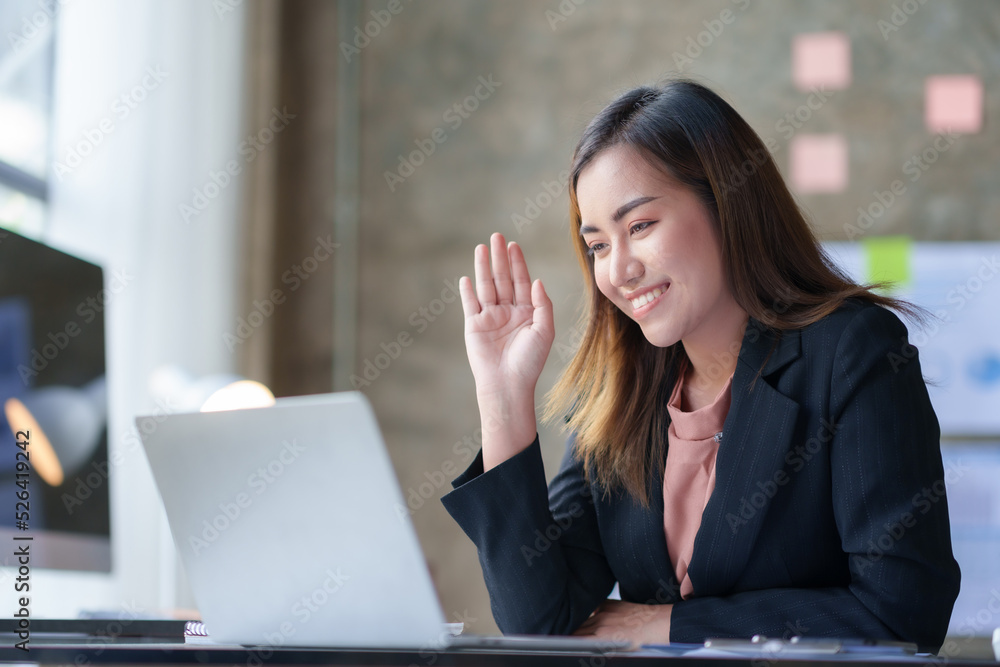 Asian businesswoman having a video call meeting on her laptop in the office comfortably and cheerfully. Asian businesswoman having a video call meeting on her laptop in the office comfortably and cheerfully.