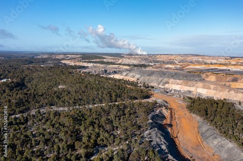 open cut coal mine with coal-fired power station in distance photo