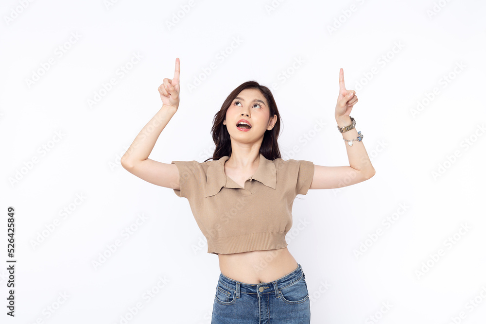 portrait of a Happy Asian woman smiling points her index finger at an empty space in the background and looks straight ahead on white background portrait of a Happy Asian woman smiling points her index finger at an empty space in the background and looks straight ahead on white background