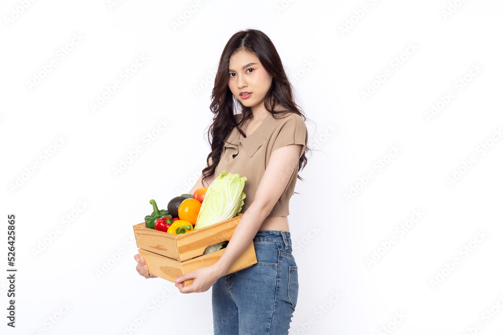 Cheerful smiling Asian woman holding a wooden box of vegetables after shopping isolated on a white background