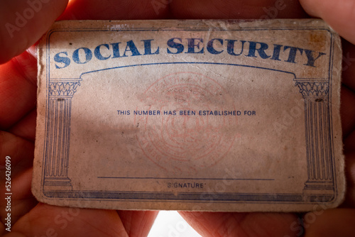 A U.S. Social Security card in the palm of a hand. photo
