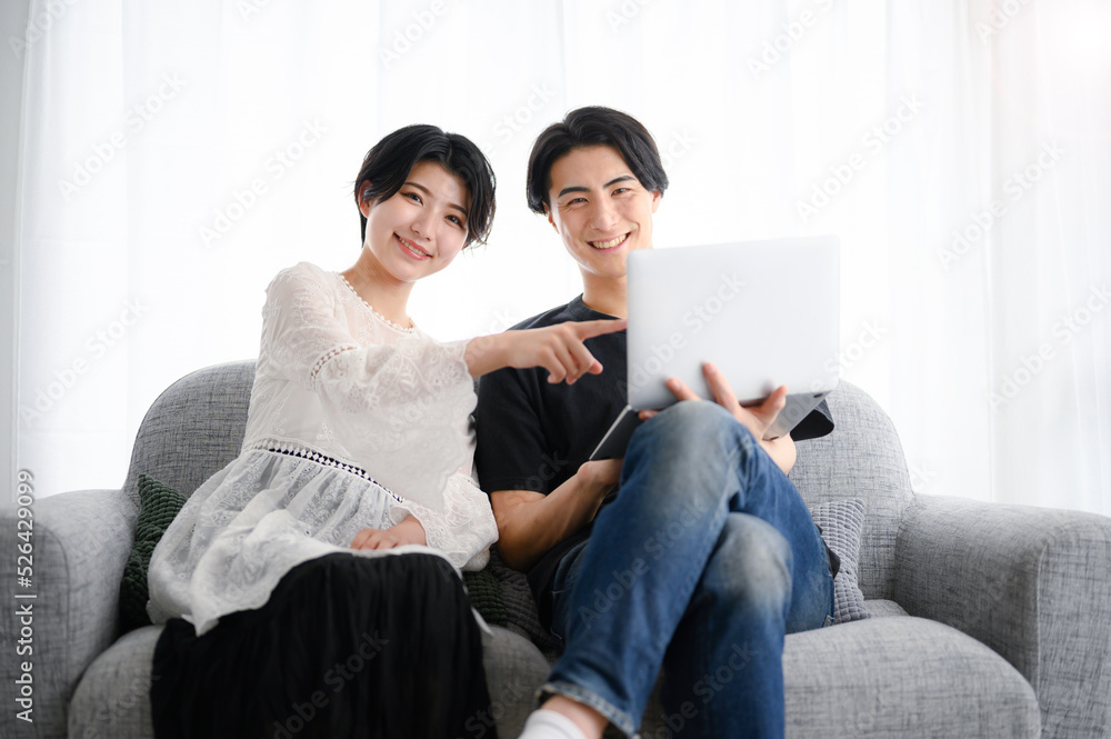 A couple sitting on a sofa, looking at the camera A couple sitting on a sofa, looking at the camera