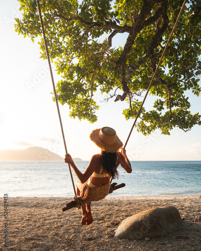 Fotografija person relaxing on the beach, swinging on a makeshift swing, Fitzroy Island