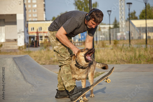 Skate and dog and man. Playing sports with a dog.