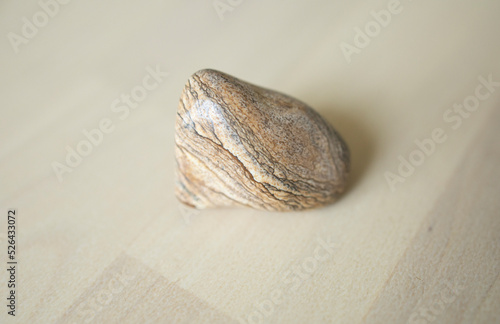 colored stone, sand jasper lies in the hand of a girl. on a light background. photo