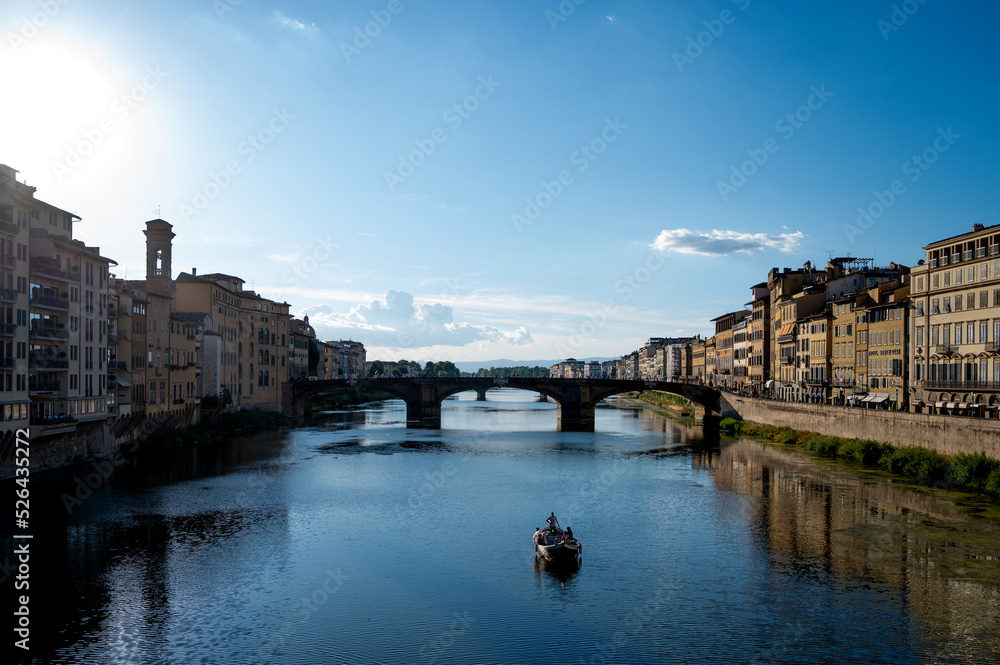 St. Trinity Bridge in Florence, Italy. Shot from famous Ponte Vecchio Florence. Image of St. Trinity bridge with Arno river and a little boat.
