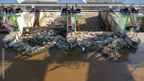 Aerial view of water released from the drainage channel of the concrete dam is a way of overflowing water in the rainy season. Top view of turbid brown forest water flows from a dam in Thailand.