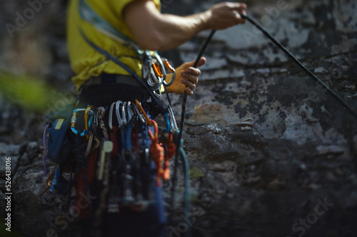 Climber works with a rope during the ascent,  face is not visible, close-up.
