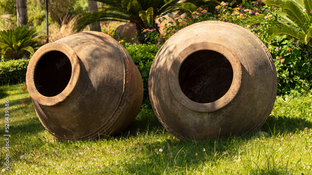 Large earthenware jugs on the green grass Large earthenware jugs on the green grass