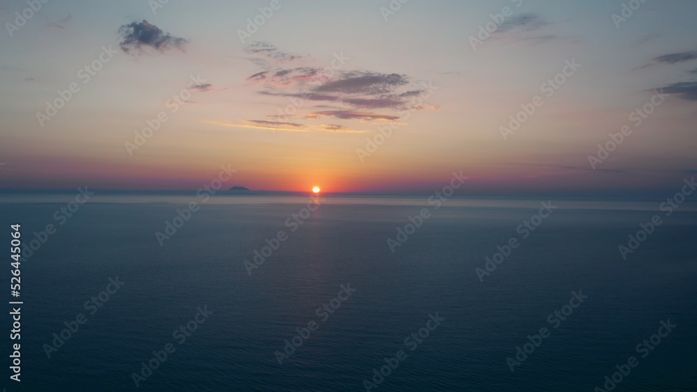 Sunset sky on the ocean with sun and orange clouds Sunset sky on the ocean with sun and orange clouds