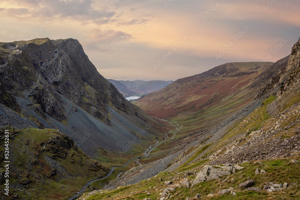 Stunning colorful landscape image of view down Honister Pass to Buttermere from Dale Head in Lake District during Autumn sunset