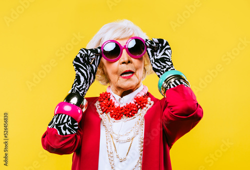 Cool and stylish senior old woman with fashionable clothes - Funny colorful portrait of elderly female lady on colored background photo