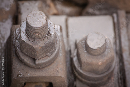 Railway track bolts. Detail of rusty screws and nut on railroad track.