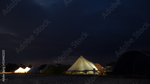 Leuchtende Zelte auf Campingplatzt mit Dramatischem Nachthimmel