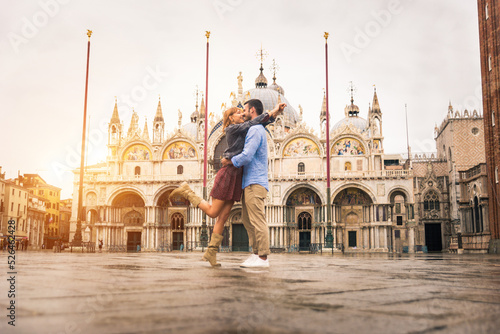 Happy beautiful couple of lovers doing romantic trip in Venice, Italy - Tourists visiting historic town of Venice and St. Mark square
