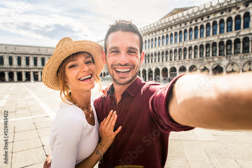 Happy beautiful couple of lovers doing romantic trip in Venice, Italy - Tourists visiting historic town of Venice and St. Mark square